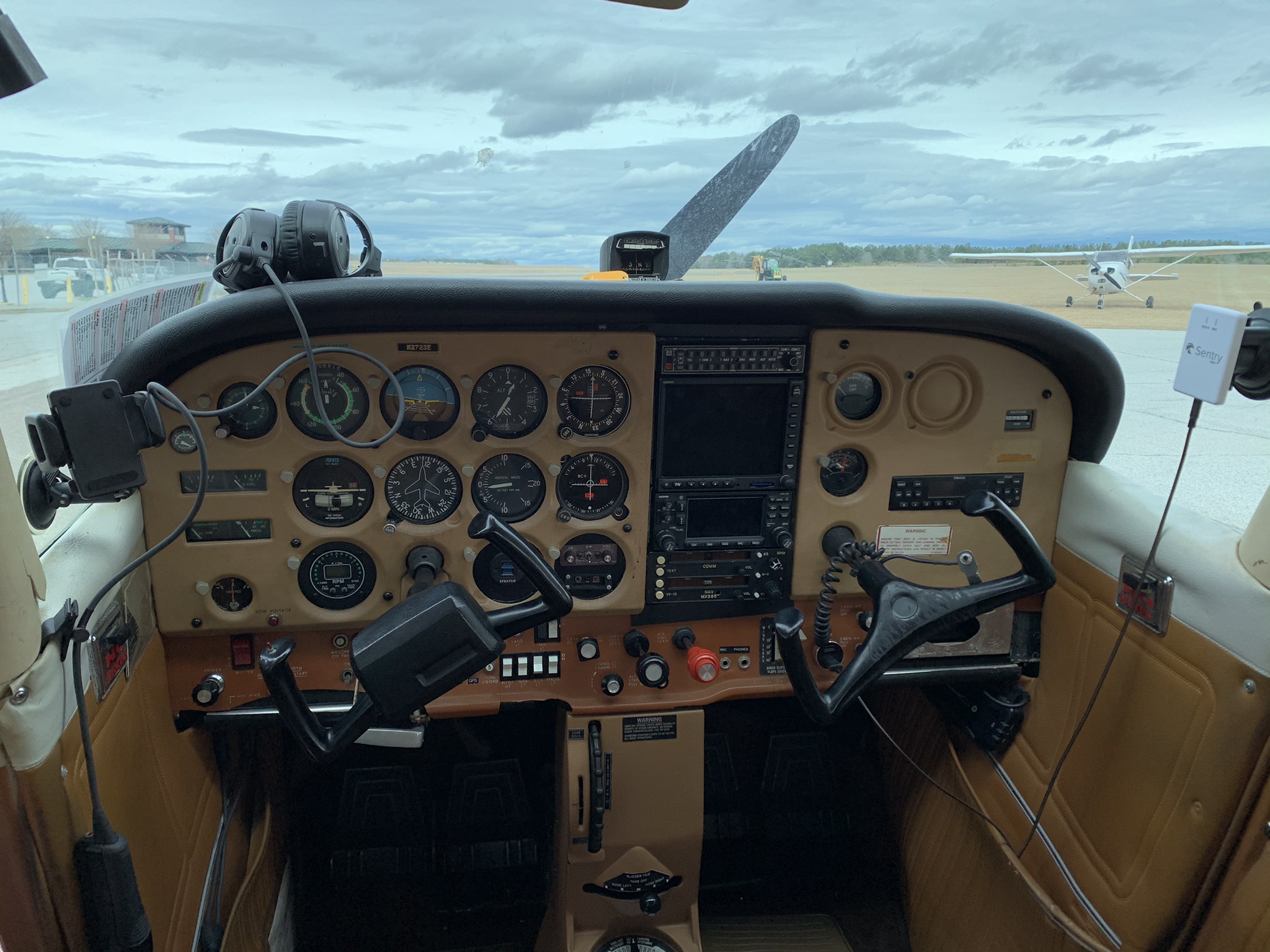 Full instrument panel and center console inside Cessna 172N N2723E viewed from the pilot seats.